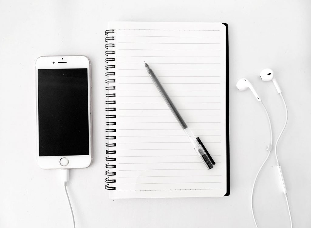 composition of notebook with pen near smartphone
