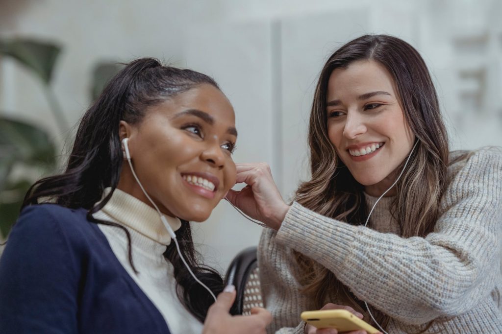 positive diverse women listening to music together