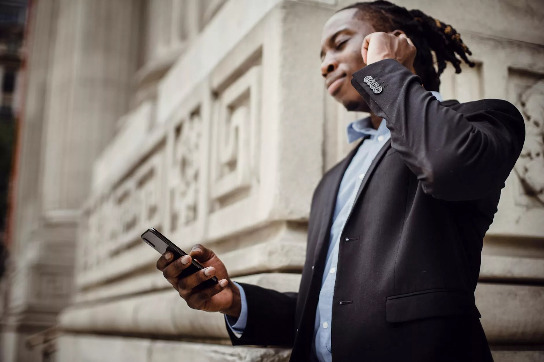 cheerful african american businessman listening to music in wireless earphones during break