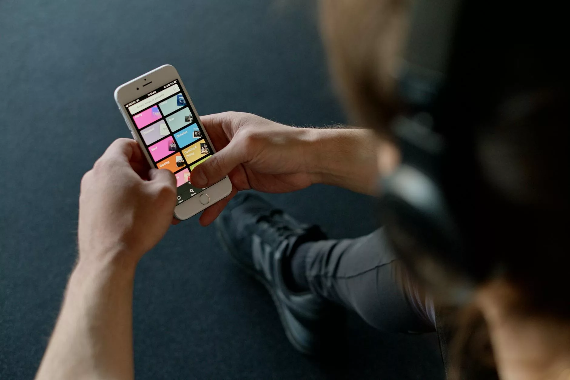 personne avec des écouteurs tenant un smartphone